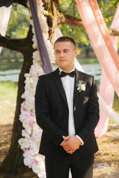 Portrait of handsome groom outside. Tie bow - Photo, image