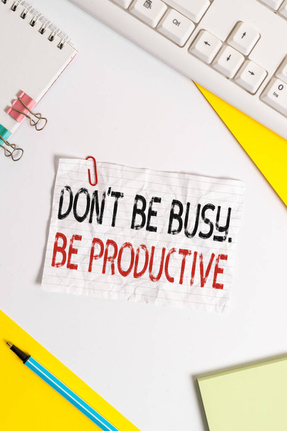 Текст слова Don 't T Be Busy Be Productive. Плоская раскладка над столом с компьютерной клавиатурой и бумага для копирования текстовых сообщений
. - Фото, изображение