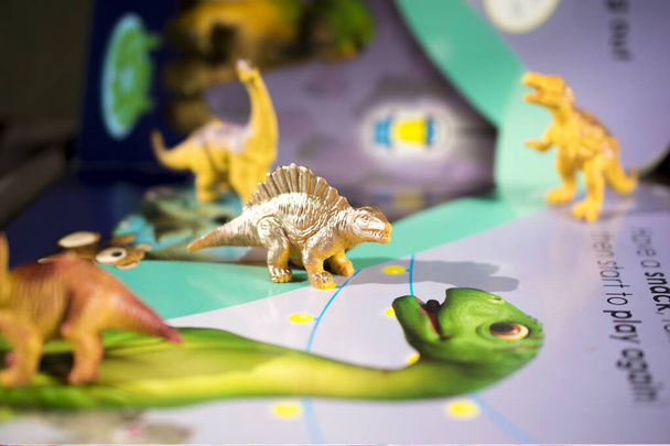 bajka o dinozaurach w książce z tekstem i zabawkami w . - Zdjęcie, obraz