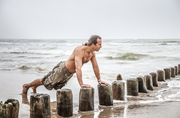 Uomo che fa flessioni sulla spiaggia
 - Foto, immagini