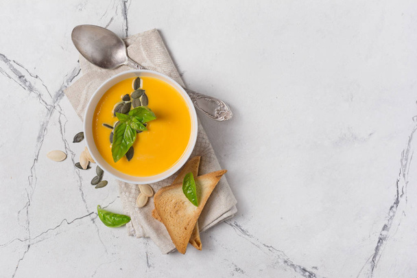 Bowl of vegetarian pumpkin soup with seeds and vintage spoon - Foto, imagen