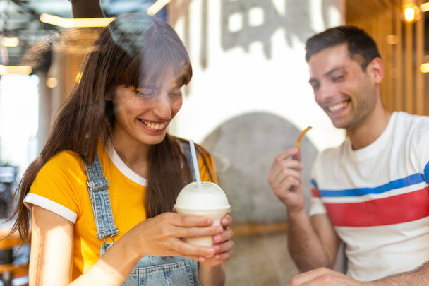 Muotokuva onnellinen nuori pari syö ruokaa kahvilassa
 - Valokuva, kuva