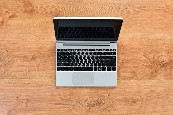 Laptop on a brown table. Top view. Free space for your text. Flat lay. - Photo, image