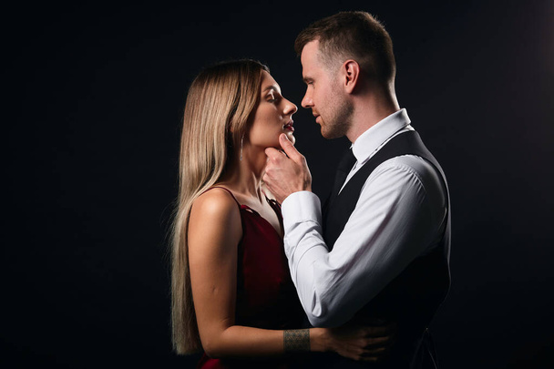 awesome young stylish giving warm, deep kiss to a lady in red dress - Fotografie, Obrázek