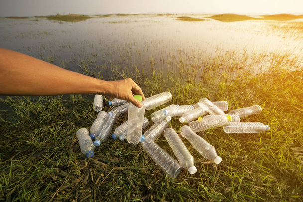 De cerca recoger la mano botella de plástico, Sequía y medio ambiente
 - Foto, Imagen