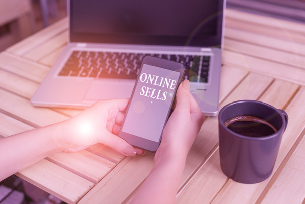 Writing note showing Online Sells. Business photo showcasing sellers directly sell goods or services over the Internet woman with laptop smartphone and office supplies technology. - Фото, изображение