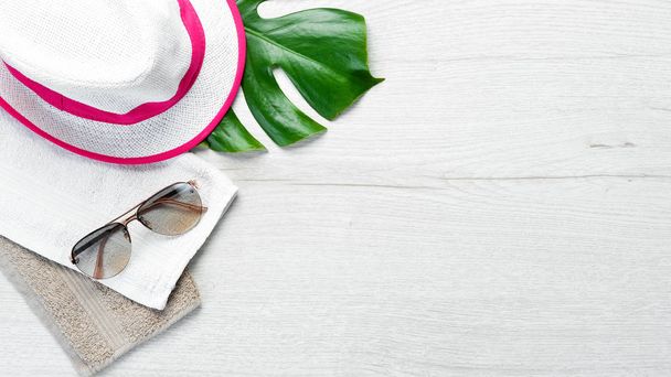 Sun glasses and hat on white wooden background. Top view. Free copy space. - 写真・画像