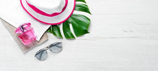 Sun glasses and hat on white wooden background. Top view. Free copy space. - 写真・画像