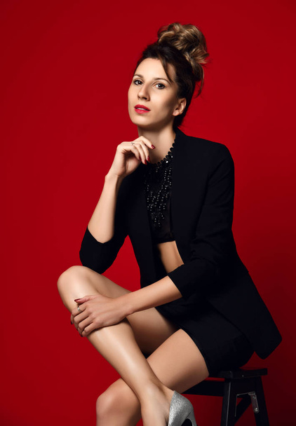 Beautiful confident business woman in sexy black stylish suit posing on red - Φωτογραφία, εικόνα