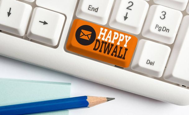 Conceptueel handschrift met Happy Diwali. Zakelijke foto presentatie festival van lichten die gevierd door miljoenen Hindoes Witte pc toetsenbord met nota papier boven de witte achtergrond. - Foto, afbeelding