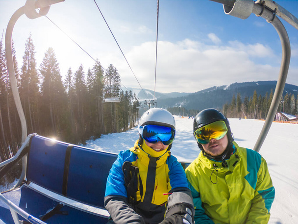 pareja tomando selfie en equipo de esquí mientras levantan hasta la colina
 - Foto, Imagen