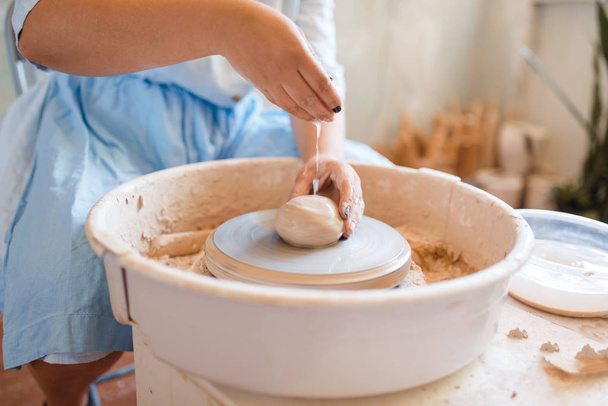 女性の陶芸家の手は陶器の車輪で動作します。鍋を成形する女性。手作りの陶芸、粘土の食器 - 写真・画像