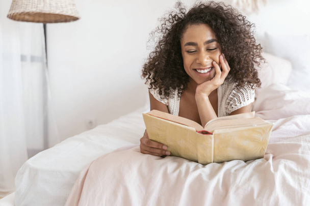 Beautiful curly haired girl reading favorite book - Foto, Bild
