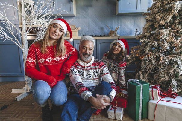 family group portrait on christmas day while they exchange gift  - 写真・画像