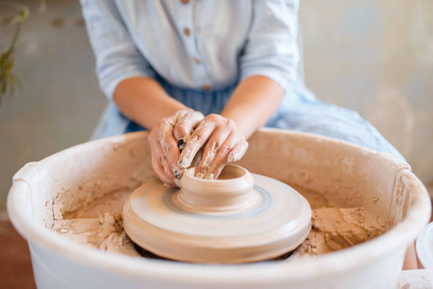 Alfarera haciendo una olla en la rueda de cerámica. Mujer moldeando un tazón. Arte cerámico hecho a mano, vajilla de arcilla
 - Foto, Imagen