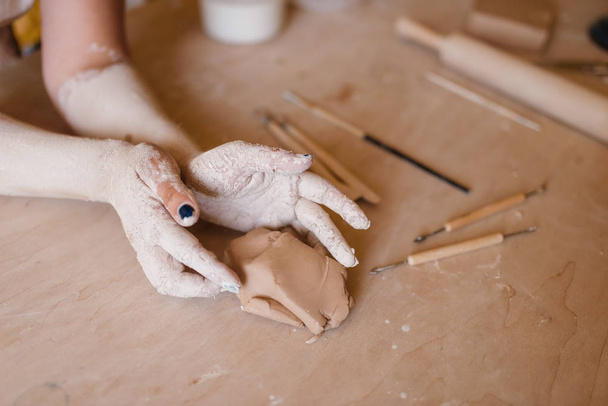 Ręce garncarki pokryte suszoną gliną, garncarnia. Kobieta układająca miskę. Ręcznie robiona ceramika, produkcja zastaw stołowych - Zdjęcie, obraz