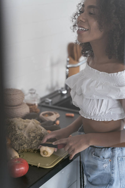 Young woman talking to a friend and cooking - Foto, Imagen