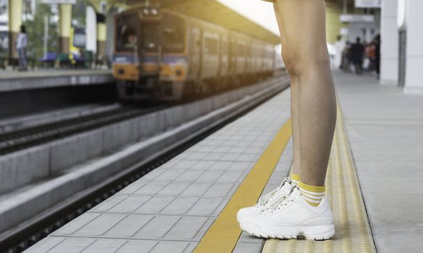 Γυναίκα στέκεται και περιμένει στο σταθμό του τρένου. Ταξιδιωτική έννοια. - Φωτογραφία, εικόνα