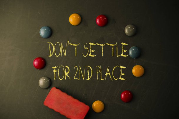 Word writing text Don T Settle For 2Nd Place. Business concept for you can be the first dont stop here Round Flat shape stones with one eraser stick to old chalk black board. - Photo, Image