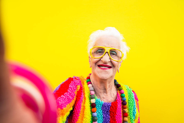 Funny grandmother portraits.granny fashion model on colored back - Фото, изображение