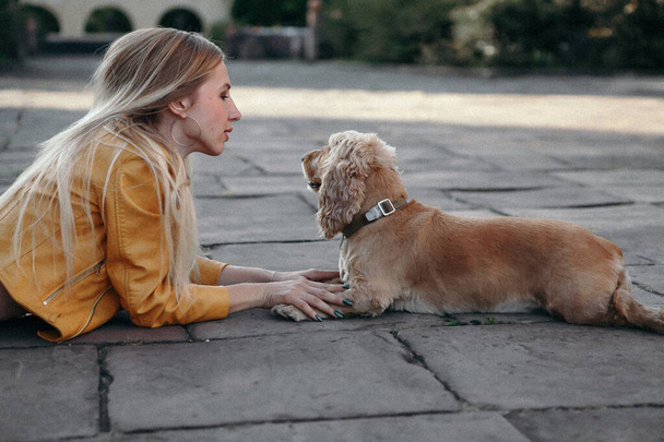 Geluid en vintage stijl. Jong meisje met hondenwandelingen in het park en geniet van de mooie zomerdag - Foto, afbeelding