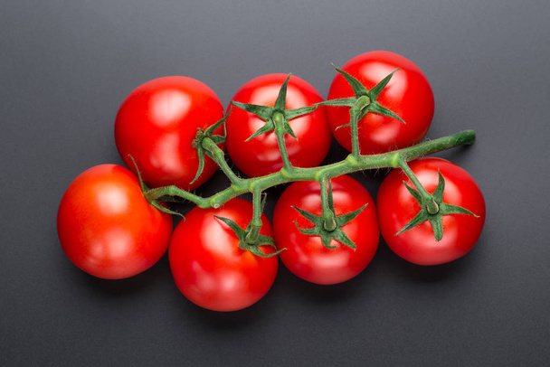 Beautiful red tomatoes on a black background, close up. - Fotó, kép