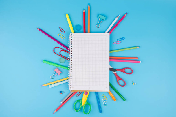 Coloridos útiles escolares y bloc de notas sobre un fondo azul. Escuela
 - Foto, imagen