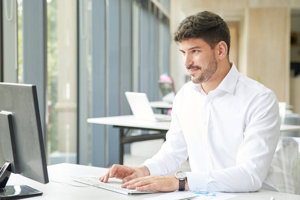 Professional businessman wearing shirt while working on computer - Zdjęcie, obraz