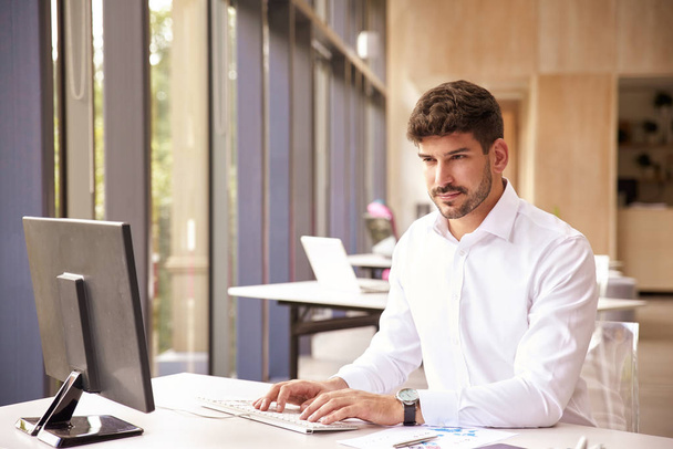 Empresario profesional que usa camisa mientras trabaja en la computadora
 - Foto, imagen