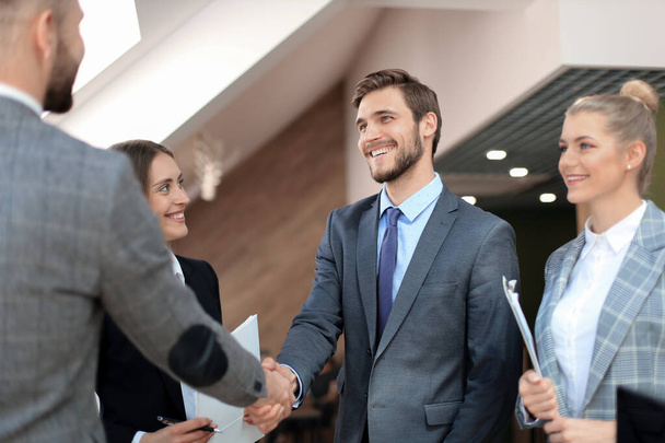 Business partners handshaking over business objects on workplace. - Foto, Imagem