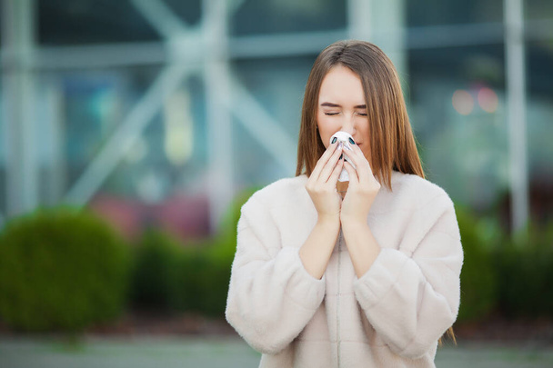 Холодно и грипп. Расстроенная женщина с гриппом и тканями на открытом воздухе
 - Фото, изображение
