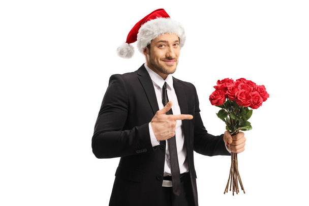 Businessman wearing a Santa Claus hat holding a bunch of red ros - Foto, immagini