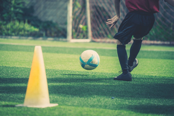 Soccer Boy is training schoppen de bal in voetbalopleiding veld - Foto, afbeelding