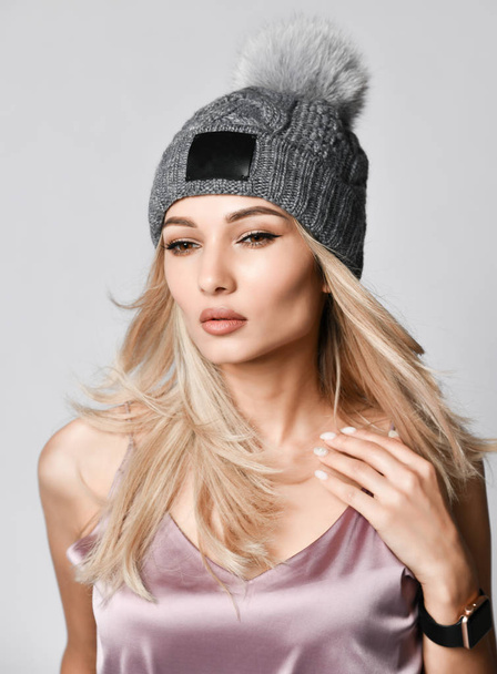 Outdoor portrait of a young beautiful fashionable lady wearing stylish knitted hat. - Photo, Image