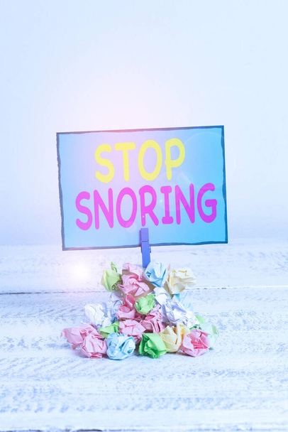 Signo de texto que muestra Stop Snoring. Foto conceptual respiración ruidosa durante el sueño debido al tejido vibratorio de las vías respiratorias Recordatorio pila de papel arrugado color pinza recordatorio espacio de madera blanco
. - Foto, imagen