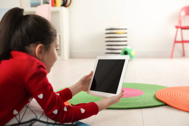 Little girl using video chat on tablet in playroom. Space for text - Foto, Bild