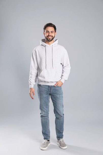 Full length portrait of young man in sweater on grey background. Mock up for design - Фото, зображення