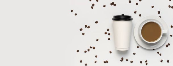 Coffee or tea paper cup, white cup with coffee, coffee beans on light gray background top view flat lay copy space. Take away coffee cup, mockup. Minimal composition, layout for design - 写真・画像