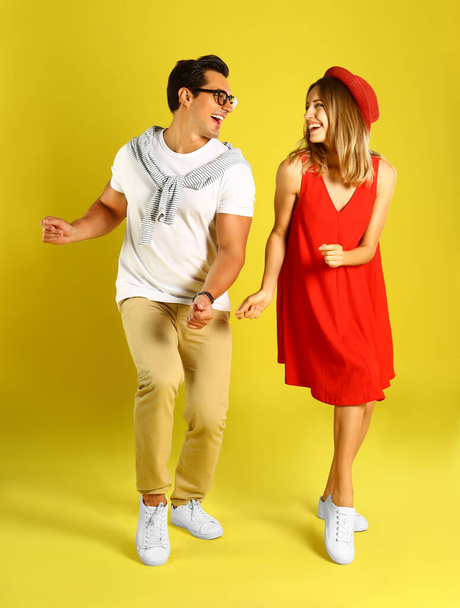 Beautiful young couple dancing on yellow background - Foto, immagini
