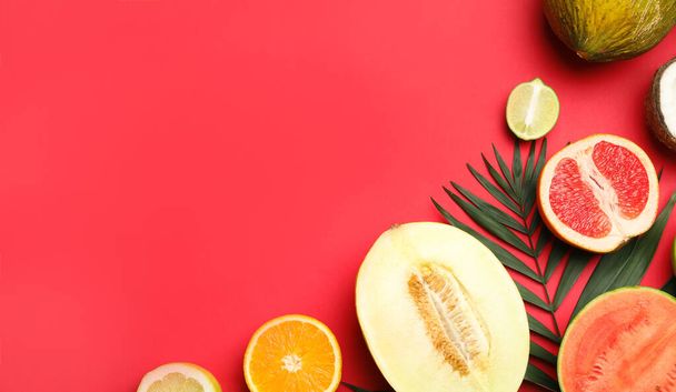 Flat lay composition with tasty melon and fresh tropical fruits on red background, space for text - Foto, immagini