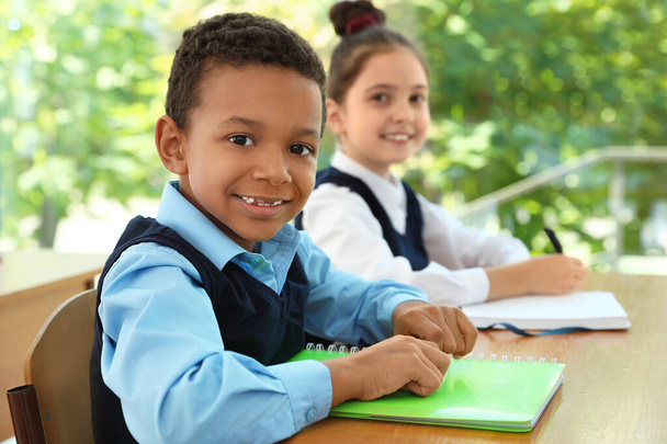 African-American boy wearing new school uniform in classroom - Valokuva, kuva