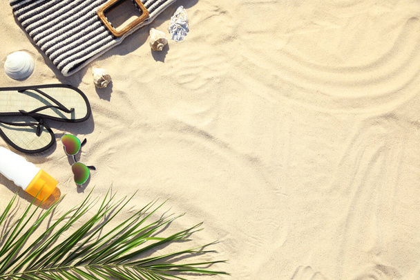 Composizione flat lay con eleganti accessori da spiaggia sulla sabbia, spazio per il testo
 - Foto, immagini
