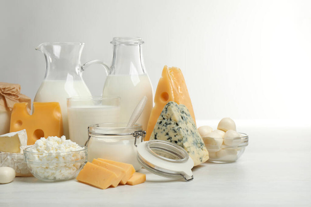Различные вкусные молочные продукты на белом столе
 - Фото, изображение