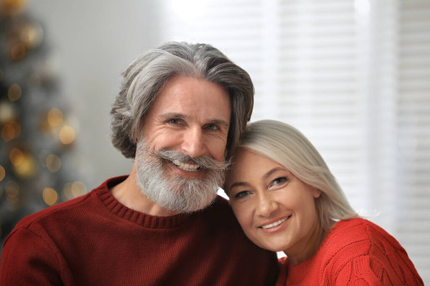Happy mature couple celebrating Christmas at home - Фото, изображение