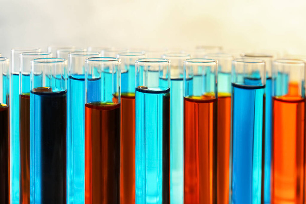 Many test tubes with different liquid samples on color background, closeup - Fotó, kép