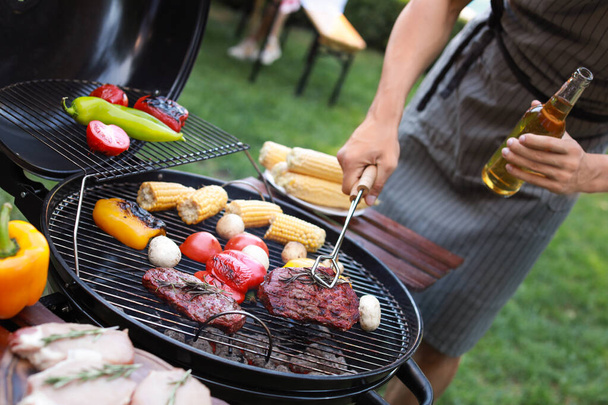 Man koken op barbecue buiten, close-up - Foto, afbeelding