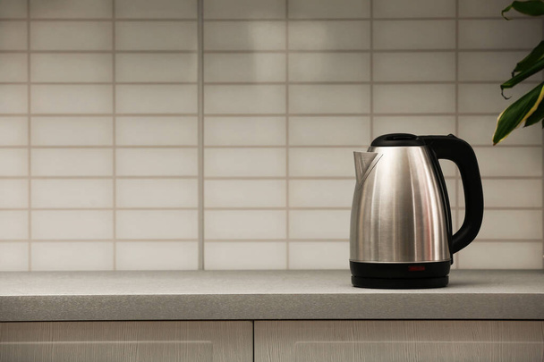 Modern electric kettle on grey kitchen counter. Space for text - Photo, Image