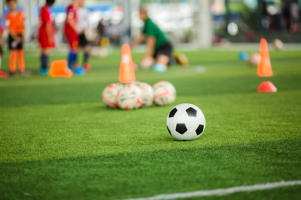 Футбольний м'яч на зеленому штучному газоні з розмитою футбольною командою трек
 - Фото, зображення