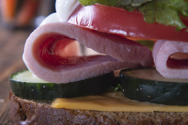 Kahverengi ekmek, jambon ve sebzeli sandviç. Makro. - Fotoğraf, Görsel