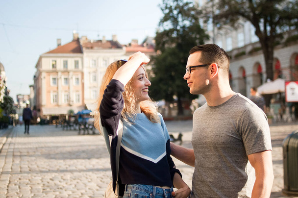 junges Touristenpaar diskutiert frühmorgens in einer antiken europäischen Stadt auf einem leeren Platz über etwas, Reiseprobleme - Foto, Bild